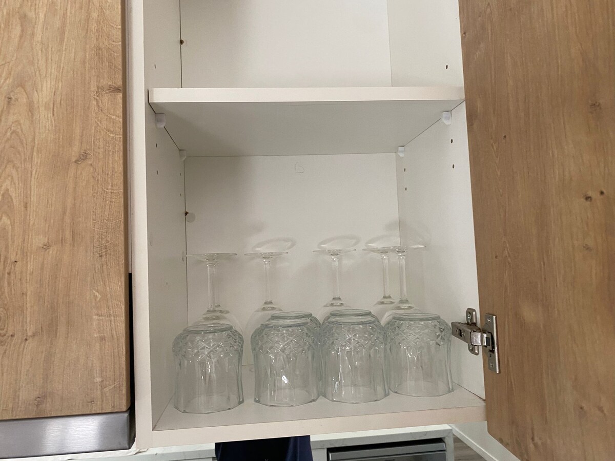 Kitchen cupboard stocked with glassware at Luxe Nest, 33 Maya Avenue