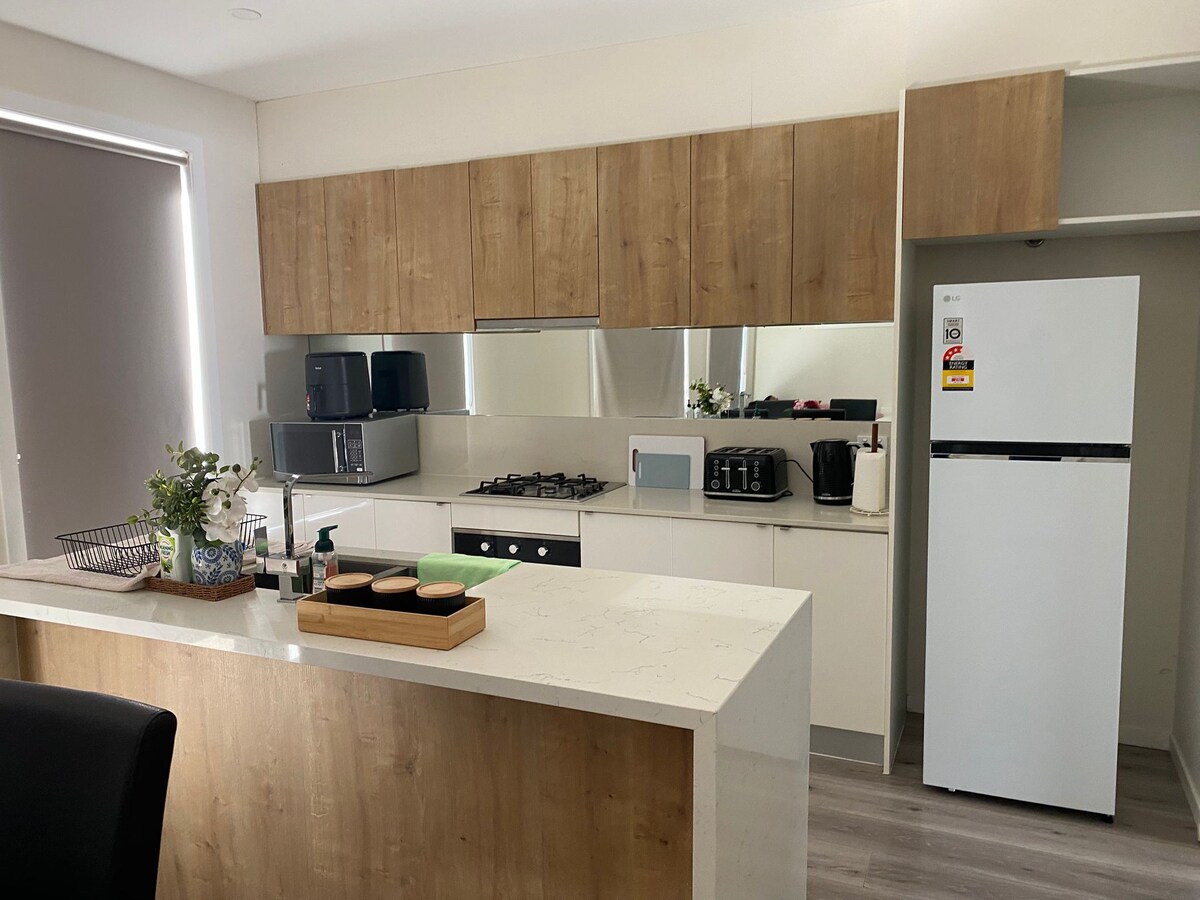Full kitchen with island, oven and fridge at Luxe Nest, 33 Maya Avenue