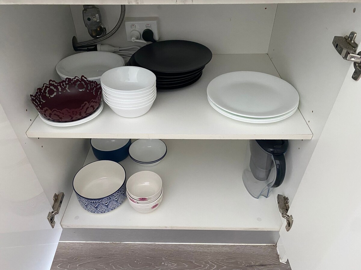 Kitchen cupboard with plates and bowls at Luxe Nest, 33 Maya Avenue