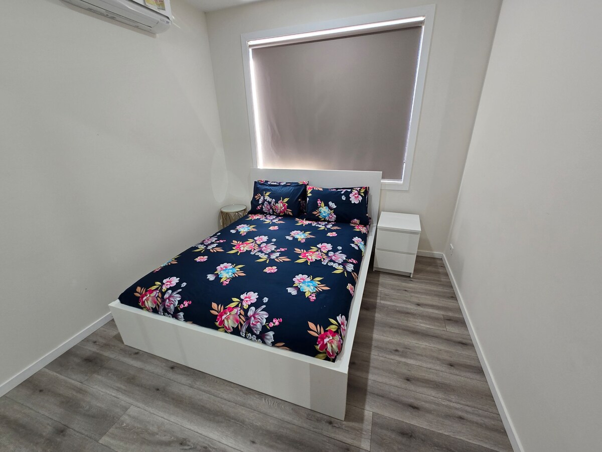 Bedroom with navy floral quilt at Luxe Nest, 33 Maya Avenue