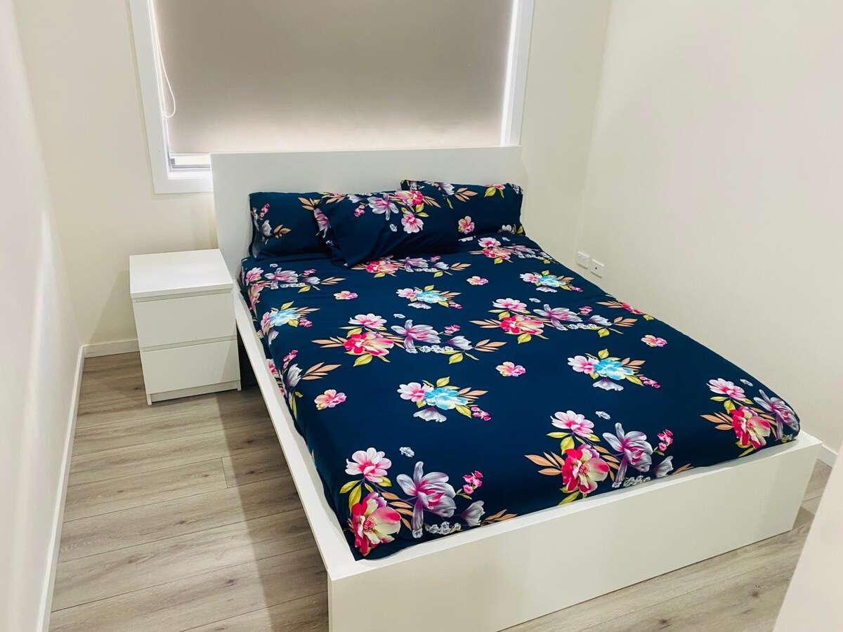 Bedroom with navy floral quilt at Luxe Nest, 33 Maya Avenue