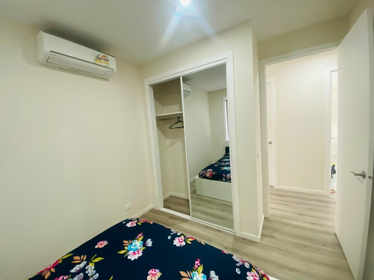 Bedroom with navy floral quilt and wardrobe at Luxe Nest, 33 Maya Avenue