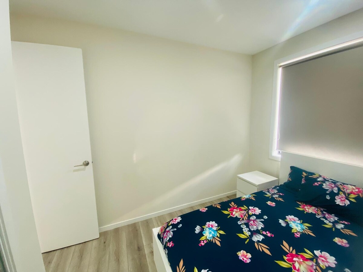 Bedroom with navy floral quilt at Luxe Nest, 33 Maya Avenue