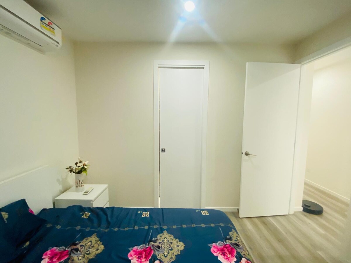 Bedroom with navy floral quilt and doorway at Luxe Nest, 33 Maya Avenue